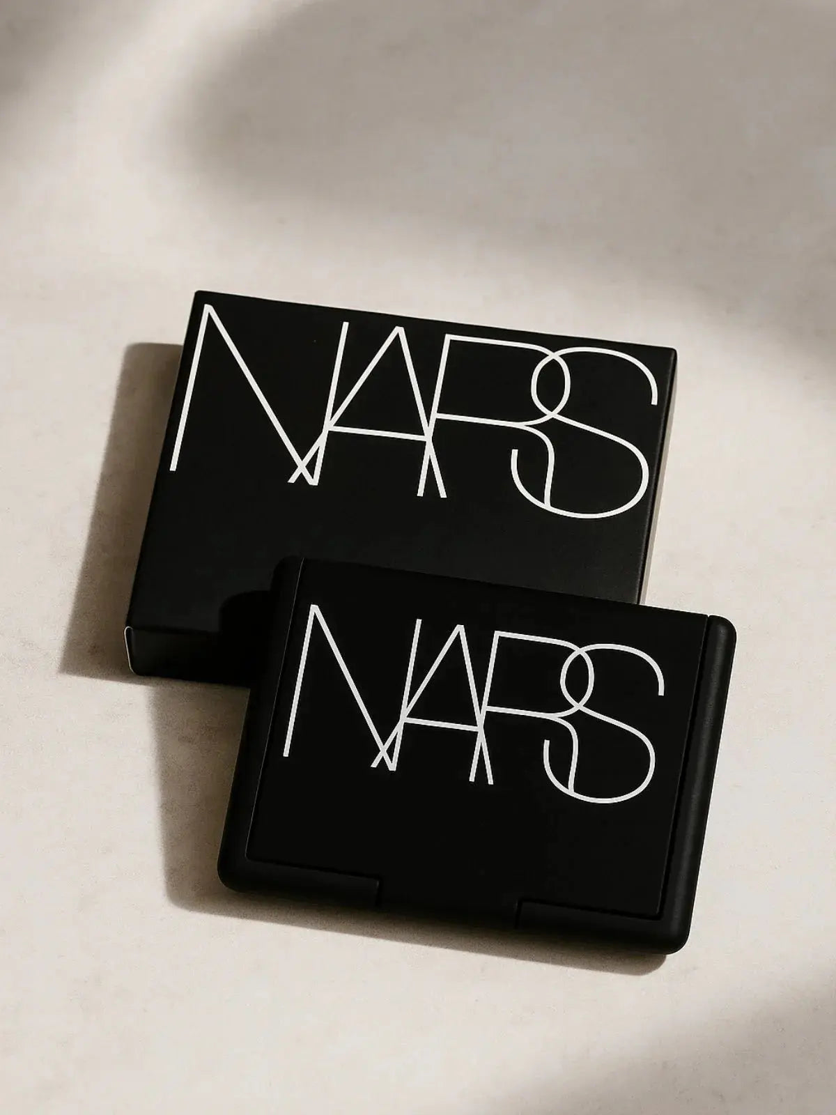 NARS black compact makeup case with white logo, sleek design for cosmetics and beauty essentials